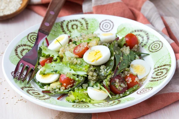 Healthy quinoa salad with tomatoes, avocados, eggs, herbs, lettu