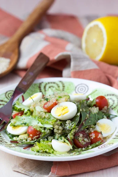 Healthy quinoa salad with tomatoes, avocados, eggs, herbs, lettu