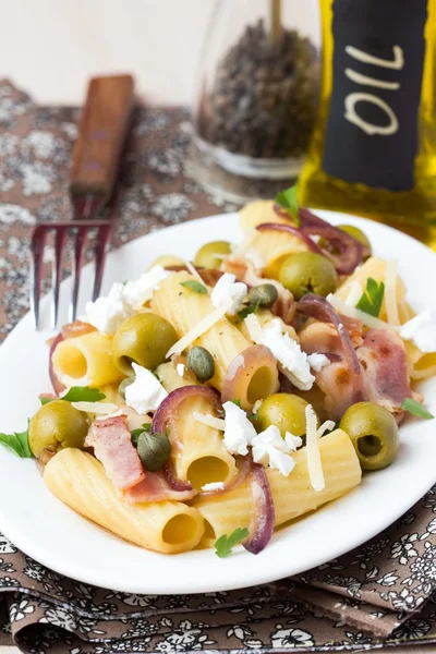 Rigatoni pasta with bacon, green olives, feta cheese, red onion,