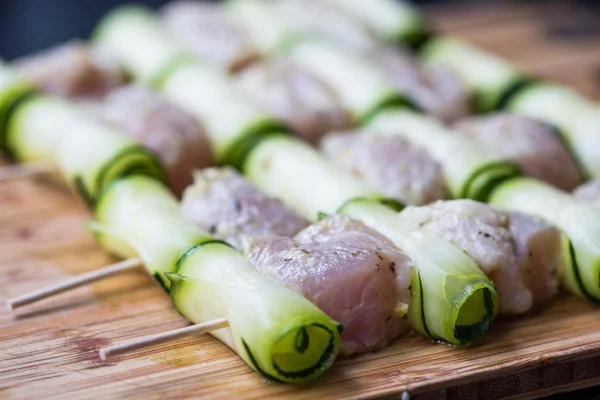 Cooking chicken kebab, shashlik on skewers with rolled zucchini,