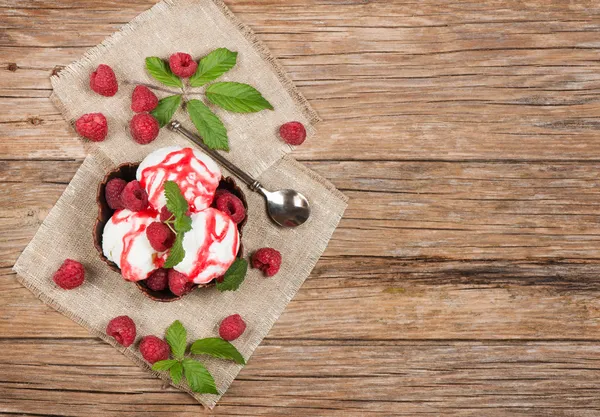 Ice cream  with fresh  raspberries and leaves from top on table