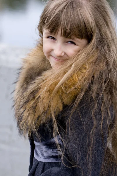 Smiling girl with a fur collar