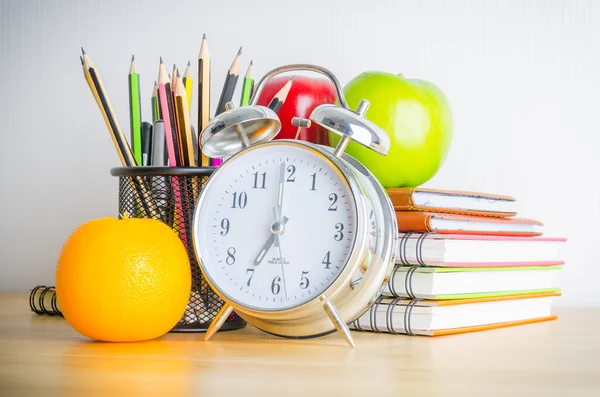 Note book , clock , pencils , apples