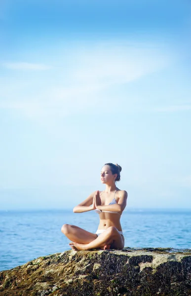 Woman practicing yoga on beach, Bali, Indonesia