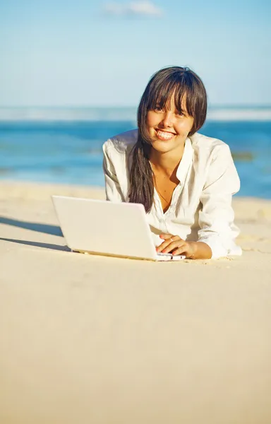 Woman with laptop on a beach