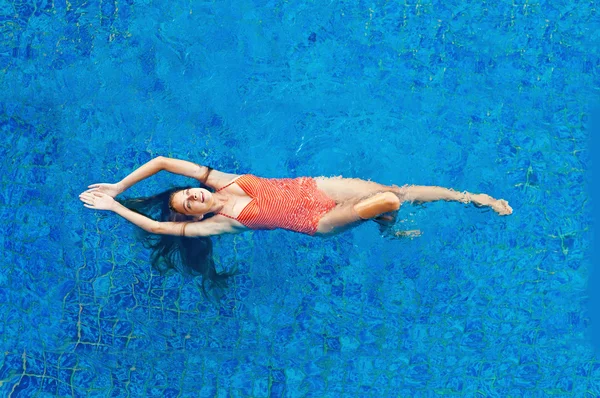 Beautiful woman in the swimming pool - top view