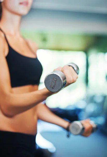 Woman in gym lifting dumbbells