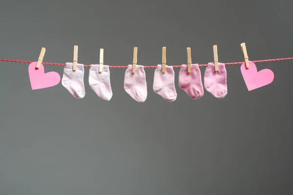 Baby girl socks and paper heart on the clothesline