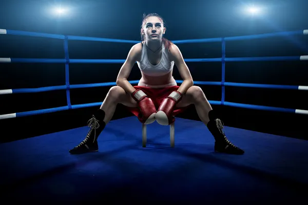 Boxing woman sitting alone in the boxing arena