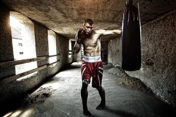Young man boxing workout in an old building