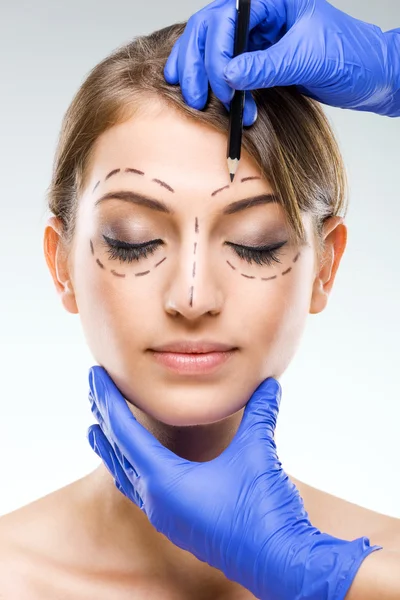 Beautiful woman face with surgical markings