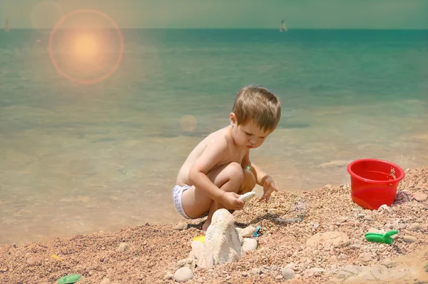 The child plays on the seashore.