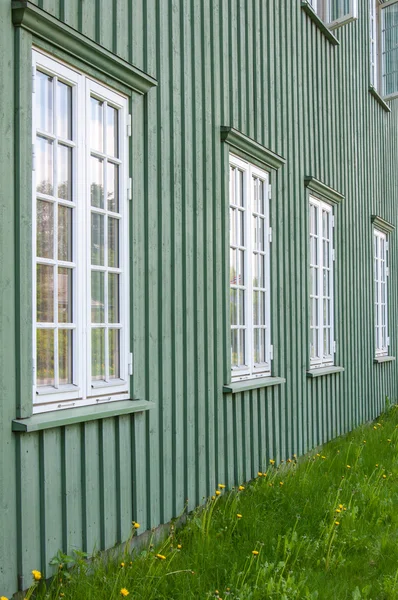 White wooden windows and green walls - traditional architecture in Norway
