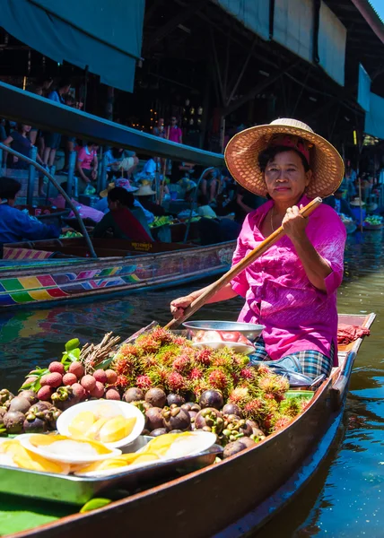 Thai locals sell food and souvenirs at famous Damnoen Saduak floating market in Thailand, in the old traditional way of selling from small boats.