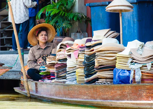 Ratchaburi, Thailand - May 24, 2014: Thai locals sell food and souvenirs at famous Damnoen Saduak floating market on  May 24, 2014 in Thailand, in the old traditional way of selling from small boats.