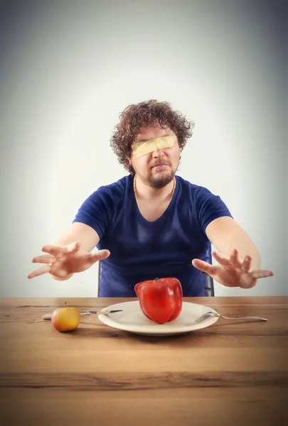 Blindfolded man wants to taste vegetables