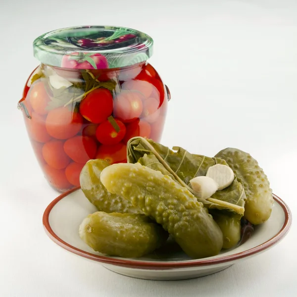 Marinated tomatoes and a dish with pickled cucumbers