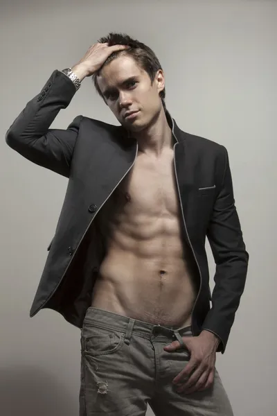 Young good-looking model in dark suite with naked torso