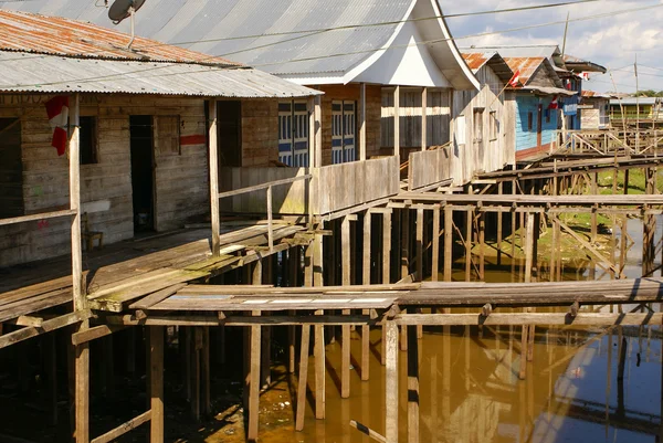 Houses on stilts rise above the polluted water in Islandia Peru