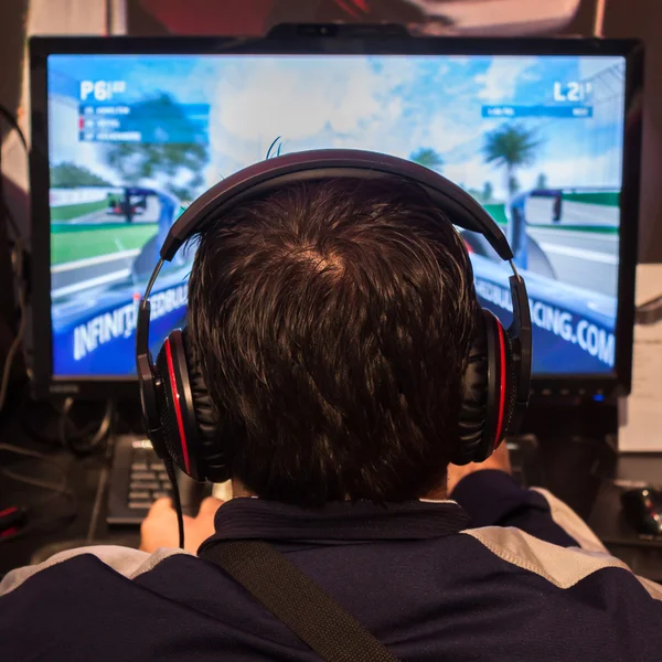 Detail of a man with headphones playing video games at G! come giocare in Milan, Italy