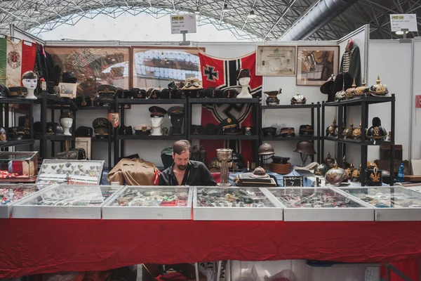 Exhibitor sitting in his stand at Militalia in Milan, Italy