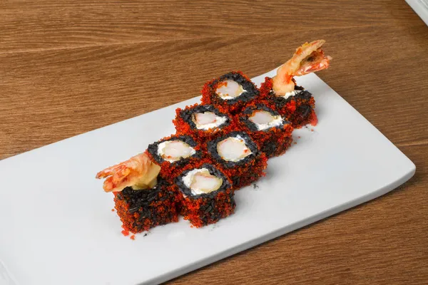 Image of black sushi with shrimp on plate in restaurant
