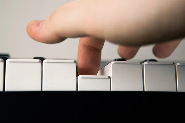 Piano keys and human finger