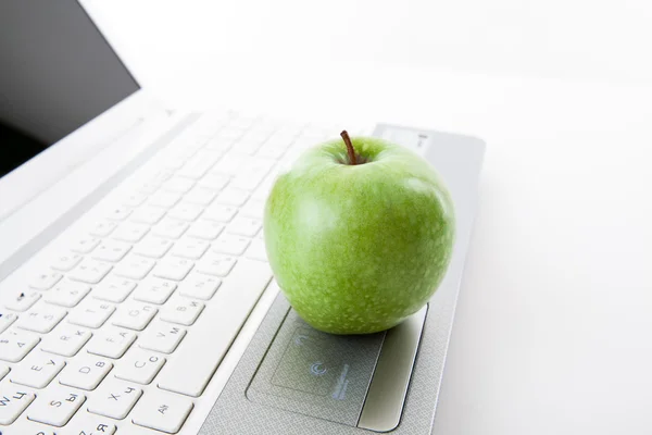 Green apple on laptop keyboard