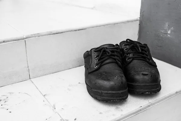 Pair of old dirty work boots in construction site