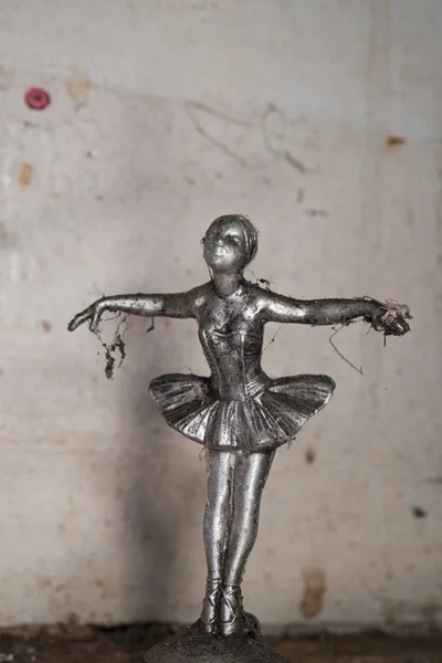 Very old dancer metallic sculpture covered by web