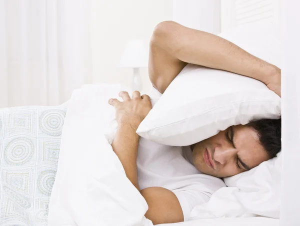 Tired Man Hiding His Head with Pillow