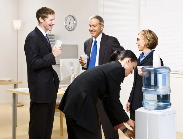 Business drinking water at water cooler