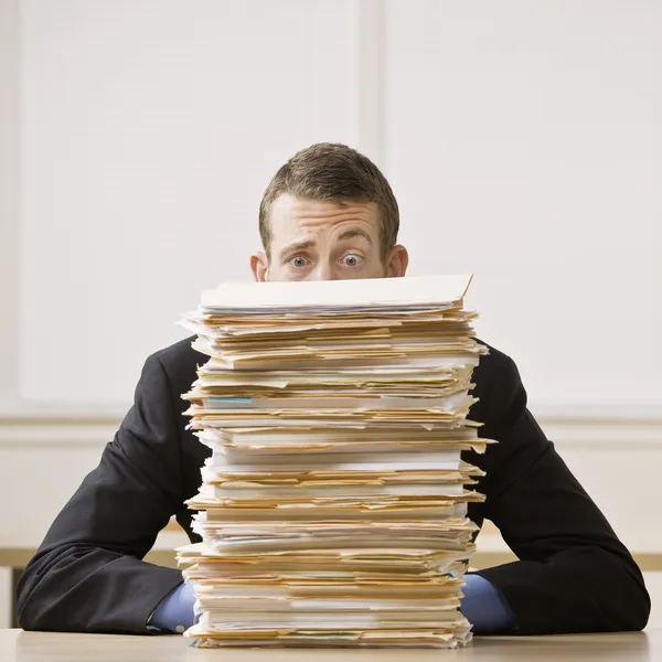 Businessman Behind Stack of File Folders