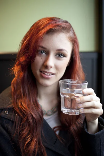 Young Woman with Beautiful Auburn Hair Drinking Water