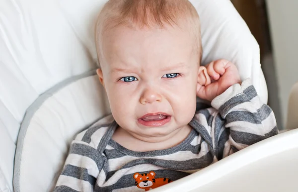 Cute little boy crying holding his ear