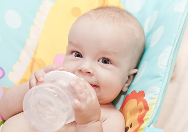 Happy baby holding bottle