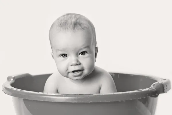 Cute little babe is bathed in a basin