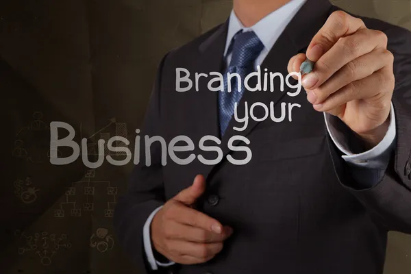 Businessman hand writing branding your business with crumpled re