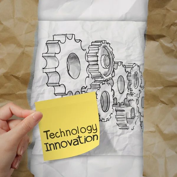 Hand holding innovation on sticky note with gear to success