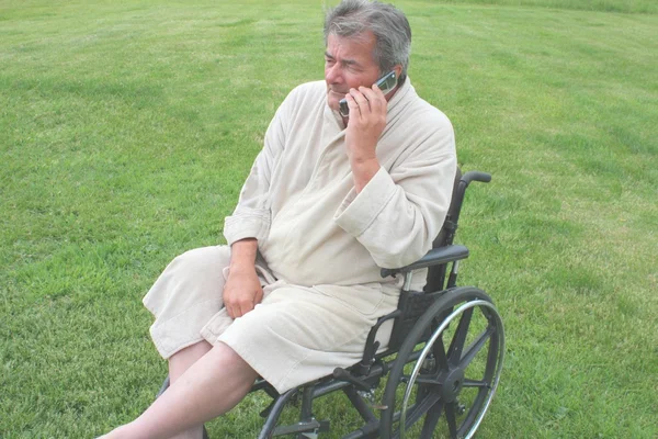 Elderly man in wheelchair with cell phone