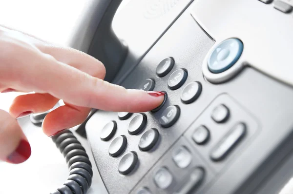 Female hand dialing a phone number