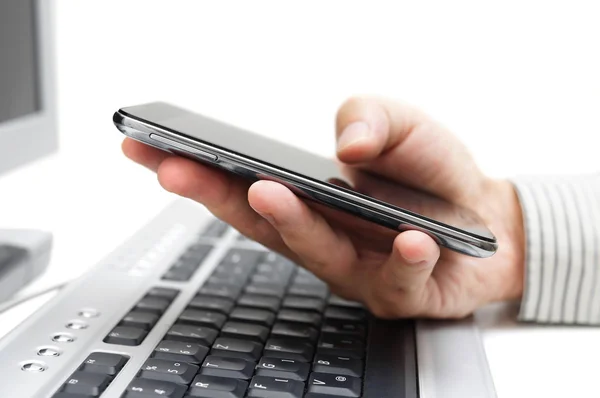 Businessman working in office with mobile phone and computer