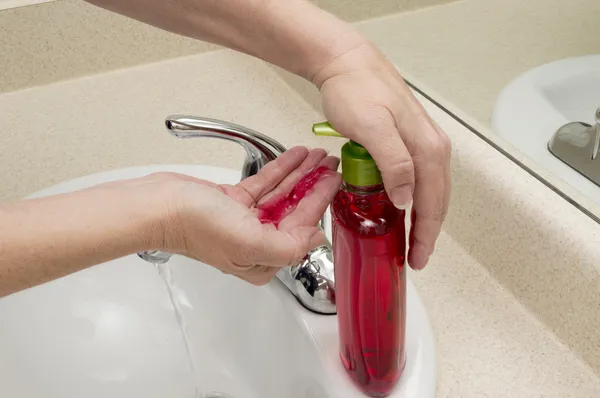 Female Hand Pumping Liquid Soap Into Palm For Washing