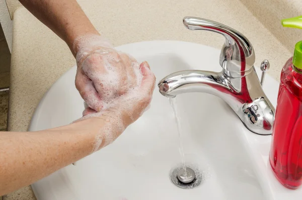 Woman Washing Hands Under Running Water