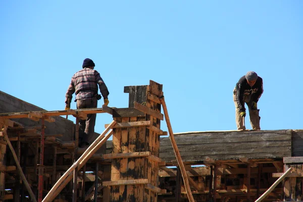 Construction of building with two workers