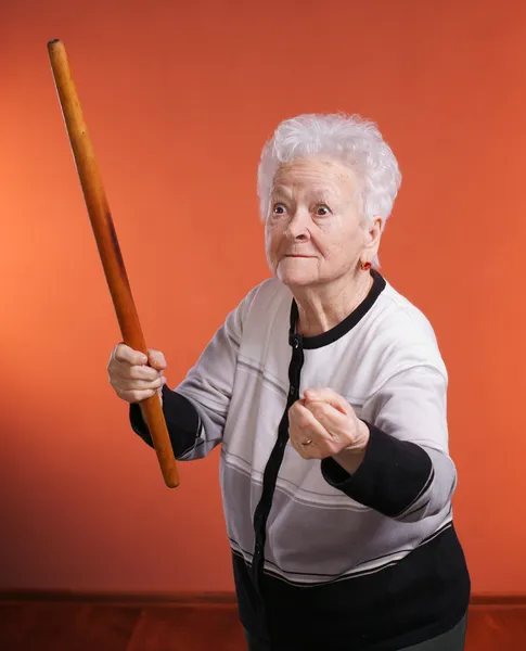 Old angry woman threatening with a rolling pin