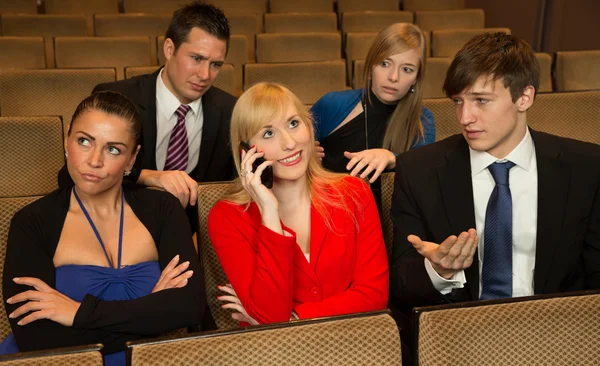 Woman in the audience annoying others with a cellphone