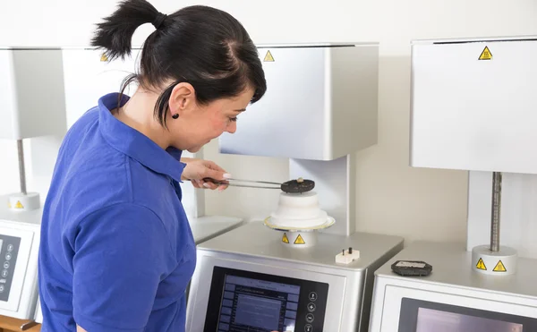 Dental technician in a laboratory taking ceramics out of the oven