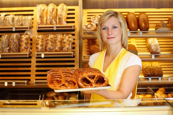 Shopkeeper in bakery with tablet of pretzels