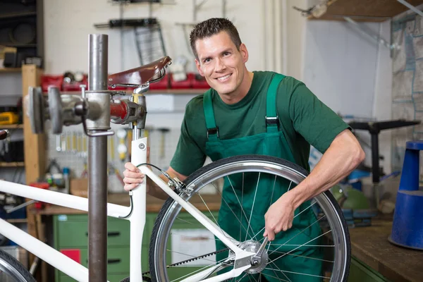 Mechanic repairing wheel on a bicycle in workshop